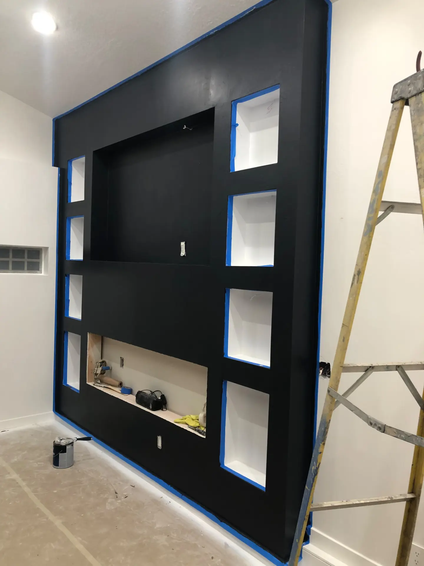 Built-in media wall painted matte black with crisp taped edges