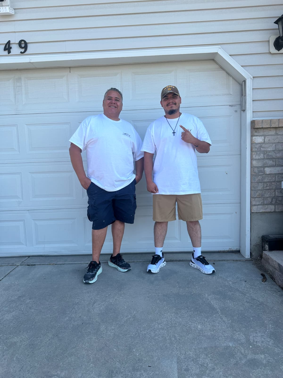Luis Trasviña and his son standing in front of a freshly painted garage