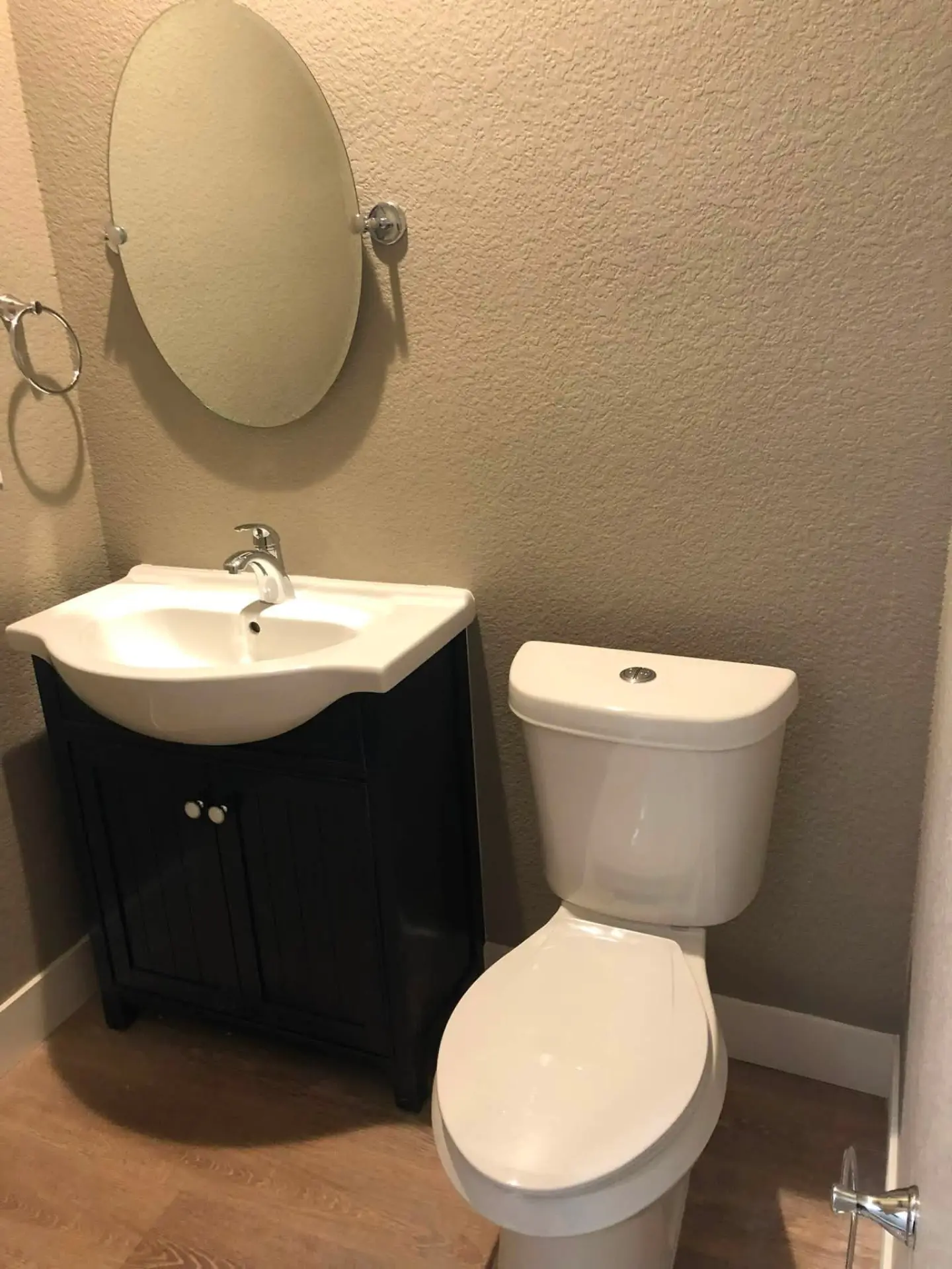 Powder room repainted warm beige with white trim