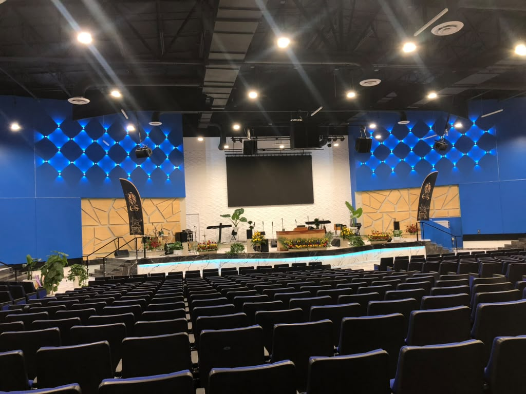 Church auditorium with blue accent walls and stage lighting after repaint