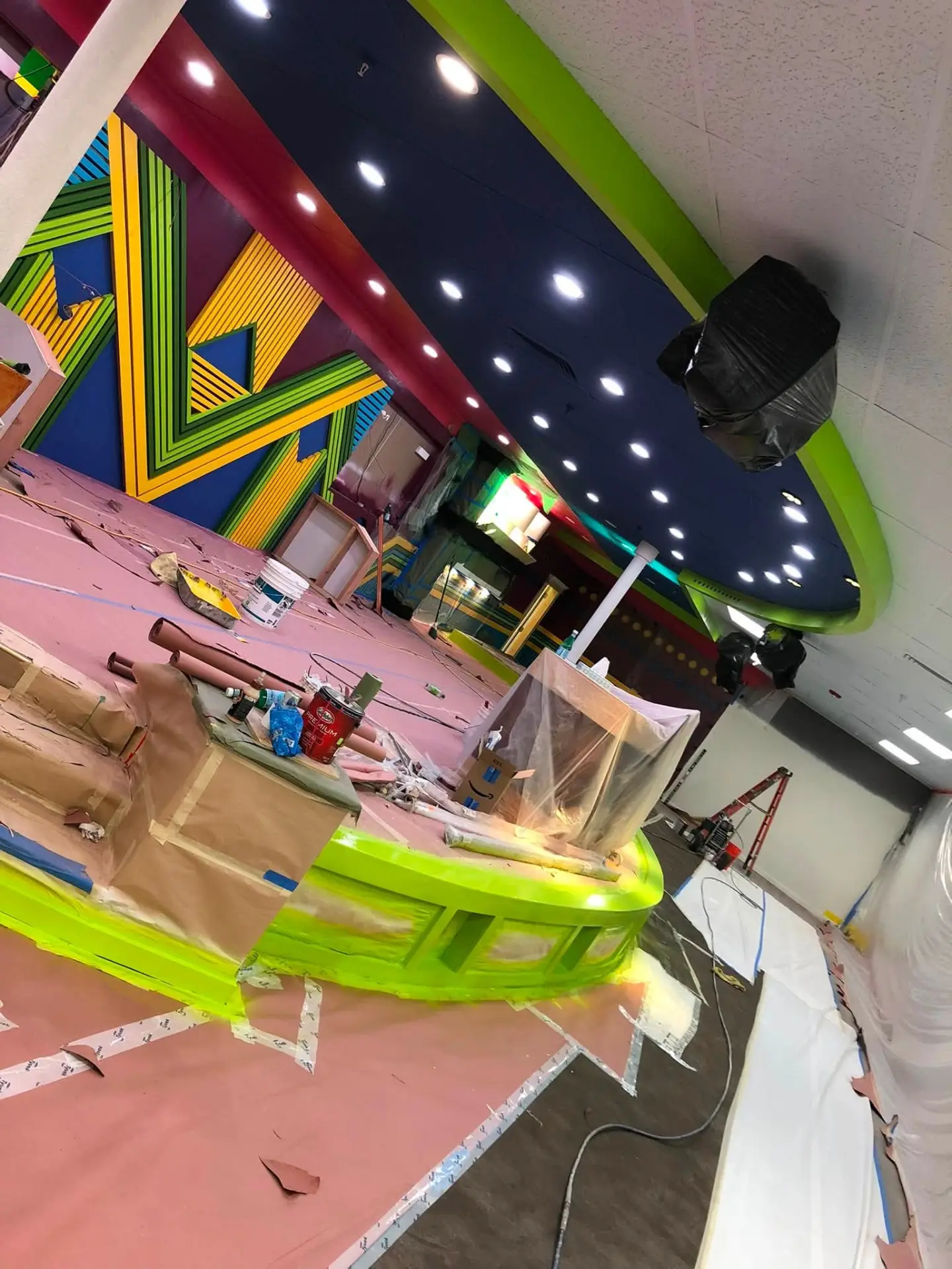 Commercial interior mid-project with masked surfaces and freshly painted bright accents