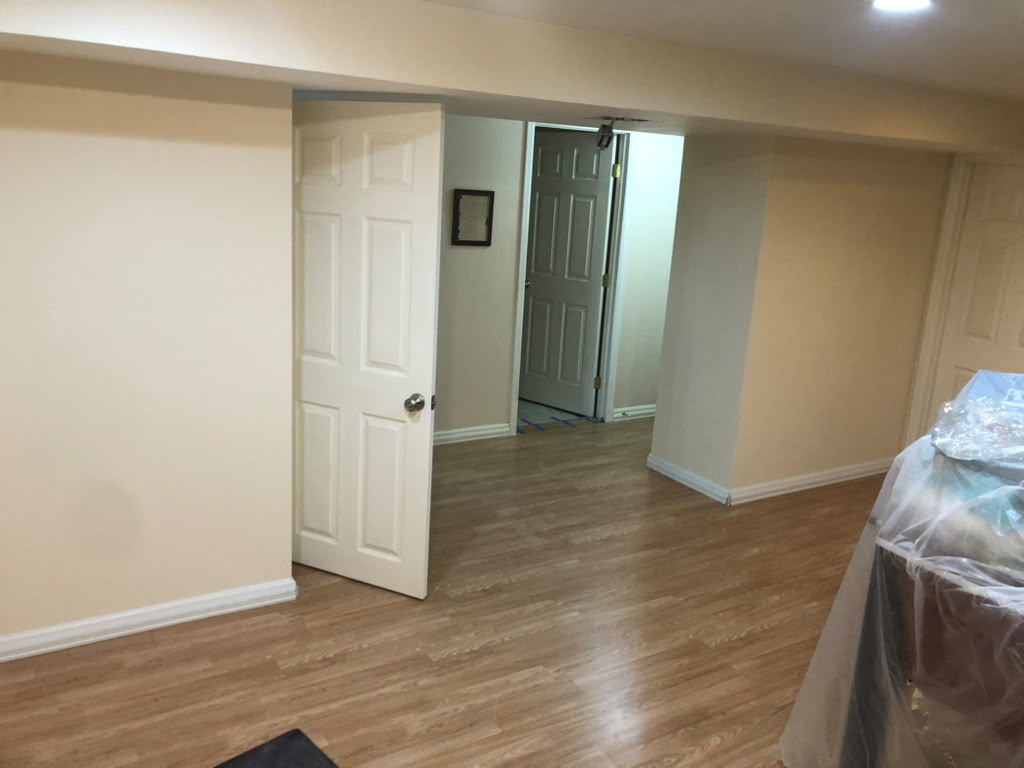 Basement living area painted warm cream with white doors and trim