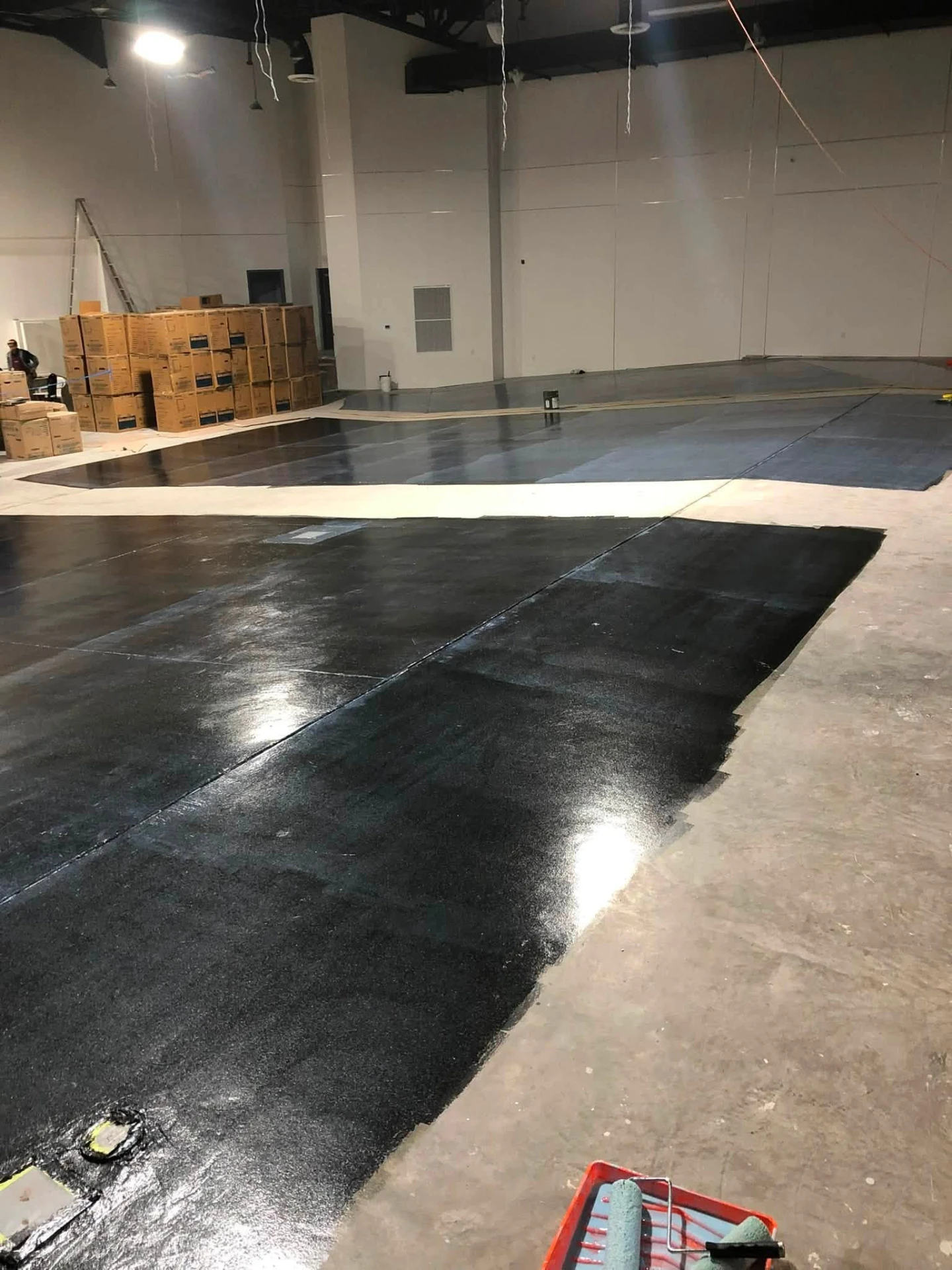 Large commercial warehouse floor coated with dark epoxy paint
