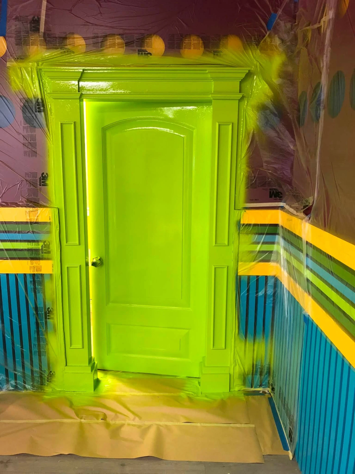 Interior door and trim sprayed bright green in a masked commercial space