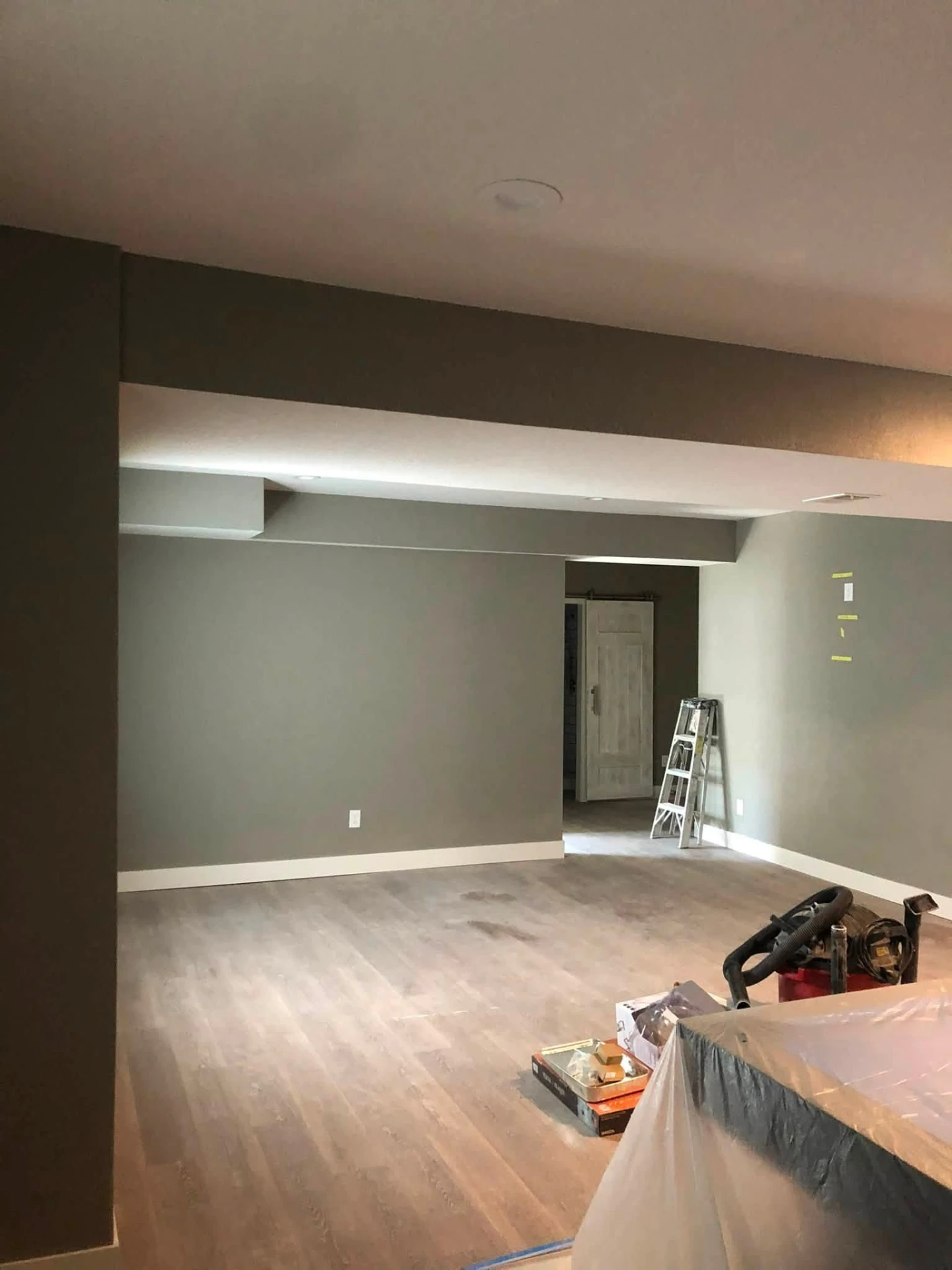 Open basement living space painted soft greige with white ceilings