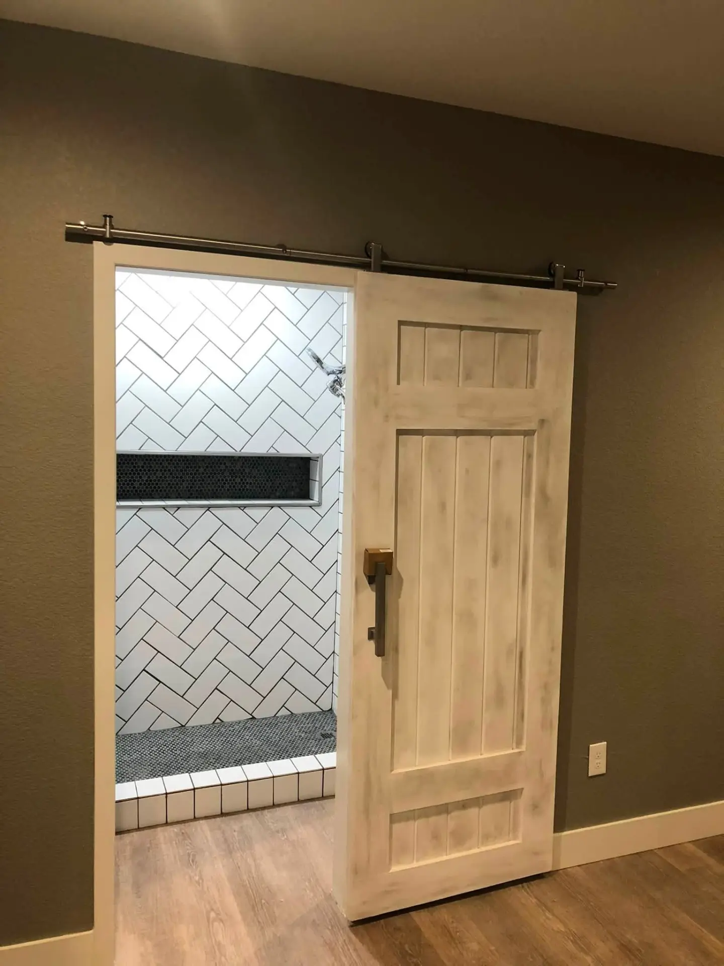 Barn door and painted walls beside a tiled walk-in shower